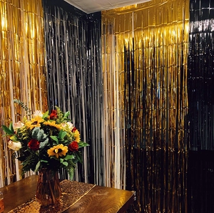 Rideau de franges or et noir pour décoration de fête avec tournesols et chemin de table brillant