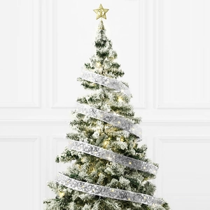 Detail of warm LED lights glowing through silver snowflake ribbons on a snowy Christmas tree