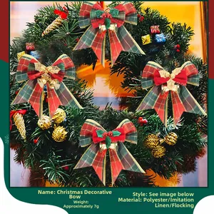 Close-up of red and green plaid Christmas bows with golden bells on tree branches