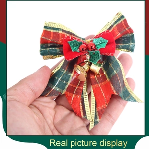 Detail of Christmas bow with gold bells and red green plaid fabric for festive tree decor