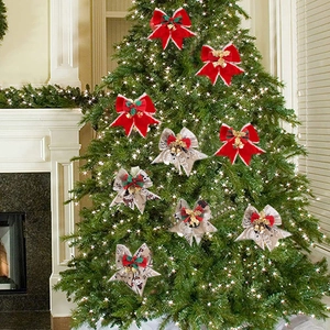 Christmas bow decorations with golden bells and red berries on a festive tree
