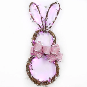 Osterhasenkranz mit rosa Schleife, Silbersternen und violetten LED-Lichtern auf Naturrattan