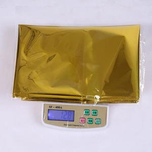 Detail showing the 128g weight of the folded rose gold PET tablecloth on a scale
