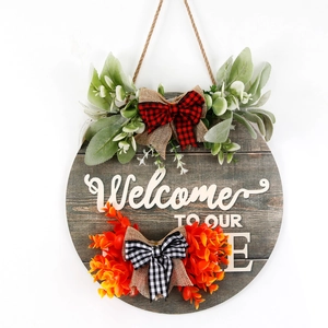 Rustic round wooden welcome sign with buffalo plaid bows and faux greenery for home decor