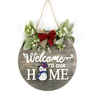 Round wooden welcome sign with snowman illustration and greenery for seasonal home decor