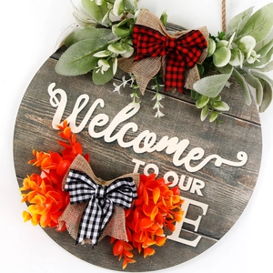 Circular wooden welcome sign with eucalyptus leaves and orange flowers for home door decor
