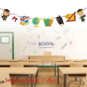 Detail of school graduation banner with cartoon students and books hanging in a classroom