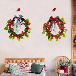 Christmas wreath set with red berries and plaid bows hanging on a white wall decor