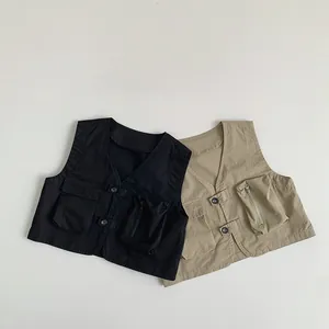 Detail of kids utility vest featuring functional multi-pocket design and button closure