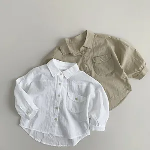 Flat lay of soft cotton linen long sleeve kids shirts in white and khaki colors