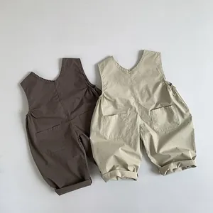 Detailed flat lay of children's cotton linen overalls in brown and beige tones