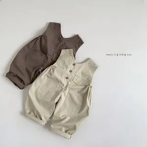 Detailed flat lay of cotton baby overalls in coffee and beige with buttons and pockets