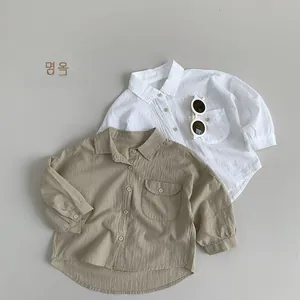 Detailed close-up of khaki and white linen cotton kids shirts with pocket and collar