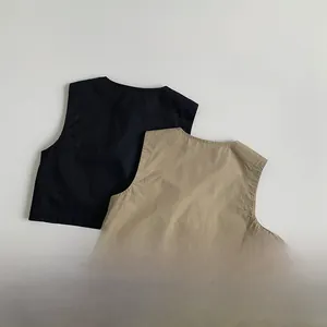Detailed flat lay of black and khaki cotton blend kids utility vests with fine stitching