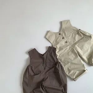 Detailed flat lay of children's cotton overalls in brown and beige with front pockets