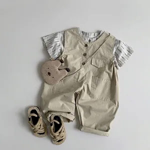 Kids short sleeve striped shirt with beige overalls and bear bag in minimalist flat lay