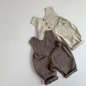 Flat lay of retro cotton kids overalls in beige and dark coffee with large front pockets