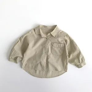 Flat lay of soft cotton linen kids shirt with chest pocket and round curved hemline