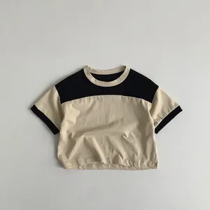 Flat lay of a children's cotton T-shirt featuring a black and beige color-block design