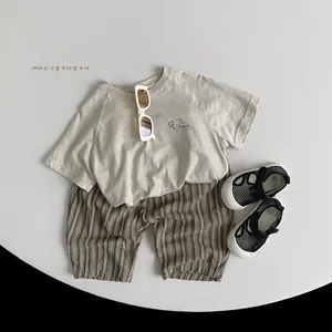 Detailed flat lay of kids summer cotton tee with striped shorts and breathable mesh sandals