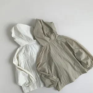 Close-up of lightweight kids sun protection jackets in white and beige with elastic cuffs