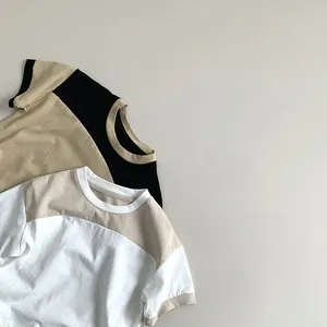 Flat lay of two color-block cotton t-shirts for kids in beige and white colorways