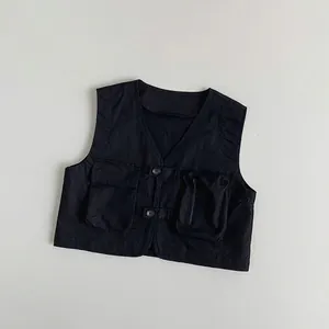 Detail view of a black tactical vest for kids with functional pockets and button closure
