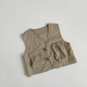 Detail of khaki kids cargo vest featuring asymmetric pockets and high-density fabric