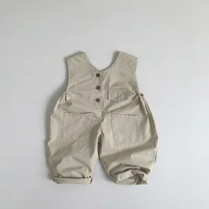 Detail view of baby cotton linen overalls with wood buttons and front pockets