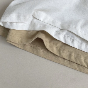Detailed close-up showing double-needle stitching on the hem of cotton kids T-shirts