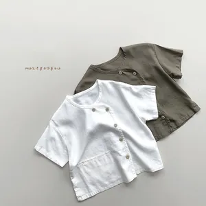 Flat lay of cotton linen kids shirts in white and olive green with side buttons