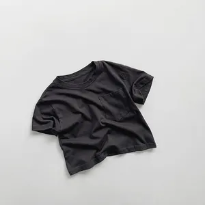 Close-up of dark grey cotton kids t-shirt showing chest pocket and fabric texture