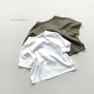 Detail view of cotton linen kids' t-shirts with side slits and natural fabric texture