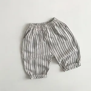 Detail of children's striped linen shorts featuring elastic waist and folded cuffs