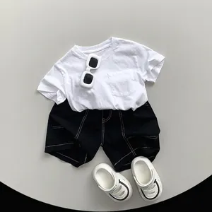 Minimalistisches Kinder-Set aus Baumwoll-T-Shirt und schwarzen Shorts mit Sandalen