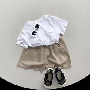 Minimalistisches Kinder-Set aus weißem Baumwoll-T-Shirt und khakifarbenen Shorts