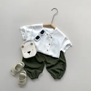 Detailed flat lay of toddler cotton linen summer set with white top and green pants