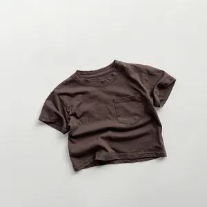 Detail of minimalist dark brown cotton T-shirt with chest pocket and round neckline