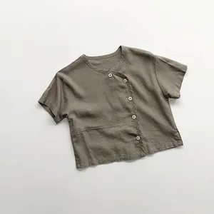 Detailed close-up of a linen kids' shirt with side button closure and rustic texture