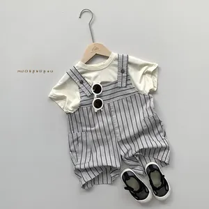 Flat lay of cream toddler T-shirt and grey striped suspender shorts with sunglasses
