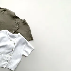 Detail of linen short sleeve shirts with unique asymmetrical button design for children