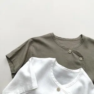 Detail of linen short-sleeve tops showing natural fabric texture and side-button collar