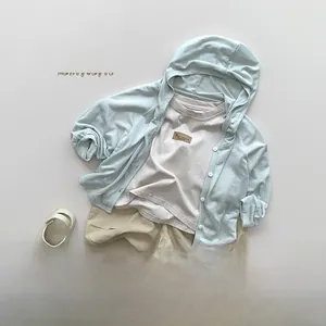 Flat lay of kids lightweight light blue hooded sun protection jacket with summer outfit