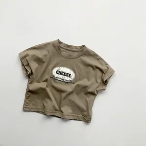 Detail of soft cotton kids T-shirt with vintage cheese print in earthy khaki tones