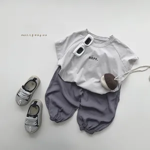 Flat lay of kids summer outfit featuring gray t-shirt and breathable harem pants