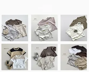Flat lay of multiple cotton kids' T-shirts in Morandi colors with slogan and stripe details