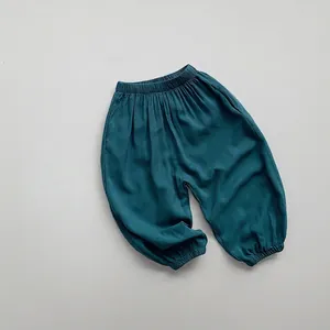Close-up of kids loose cotton harem pants in dark green with elastic ankles and waist