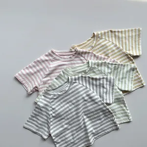Détail de quatre t-shirts à rayures pastel pour enfants en coton doux et finitions propres