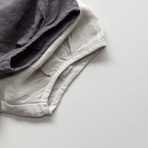 Vue détaillée de la texture du lin naturel et des coutures du short d'été enfant
