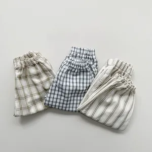 Detailed macro view of kids plaid and striped cotton pants featuring elastic waistbands